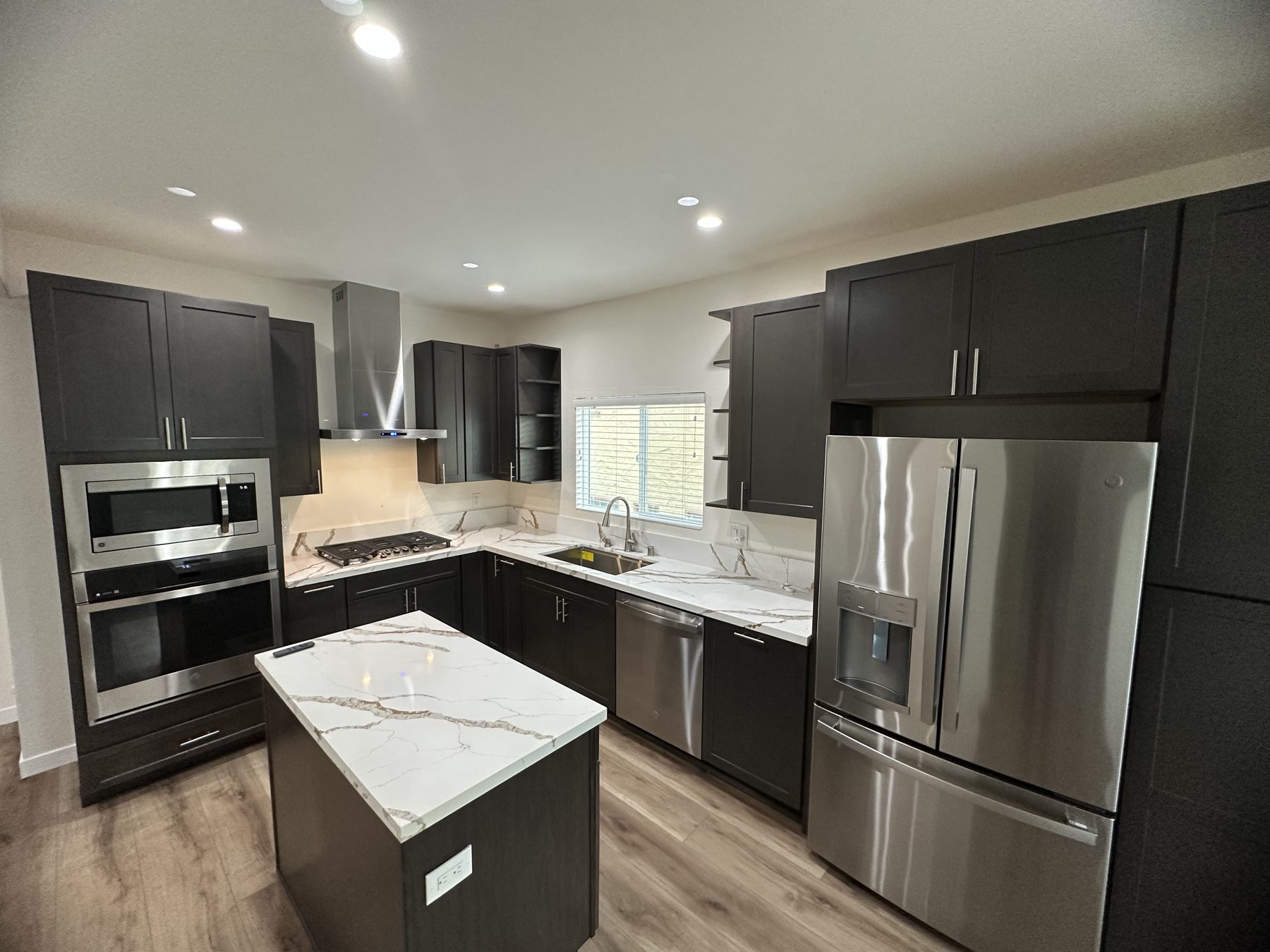 Fully renovated kitchen with island, stainless steel appliances and quartz-look counters at 1148 S Rimpau Blvd