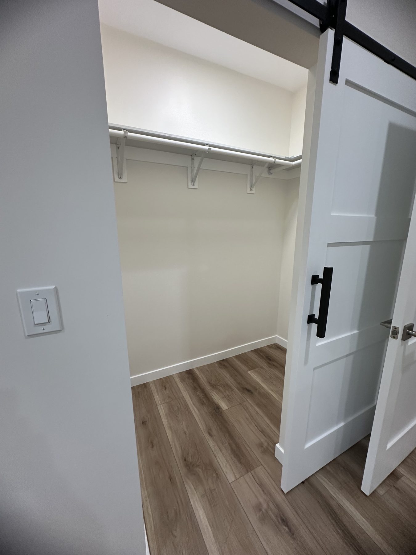 Walk-in closet with hanging rod, shelf and sliding barn door at 1148 S Rimpau Blvd